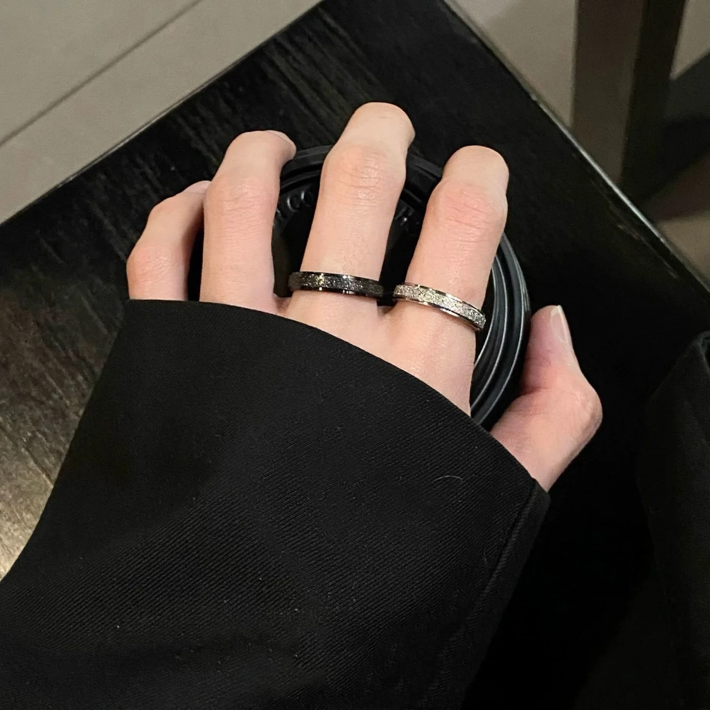 Frosted Star-Dust Ring — Matte black and matte white frosted rings with fine glitter, worn on the hand