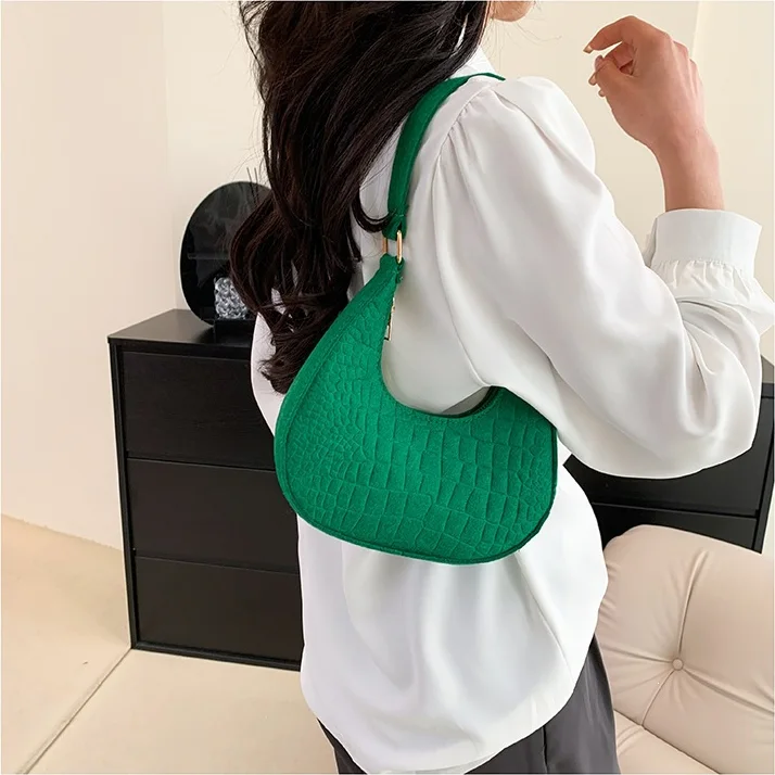 Felt Crescent Underarm Bag — Soft felt crescent underarm bag with an embossed face, worn on the shoulder